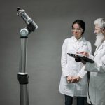 Pesquisadores trabalham com tecnologia robótica em um laboratório.