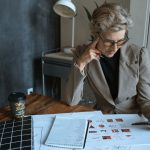 Empreendedora analisa documentos em uma mesa de trabalho em um escritório doméstico moderno.
