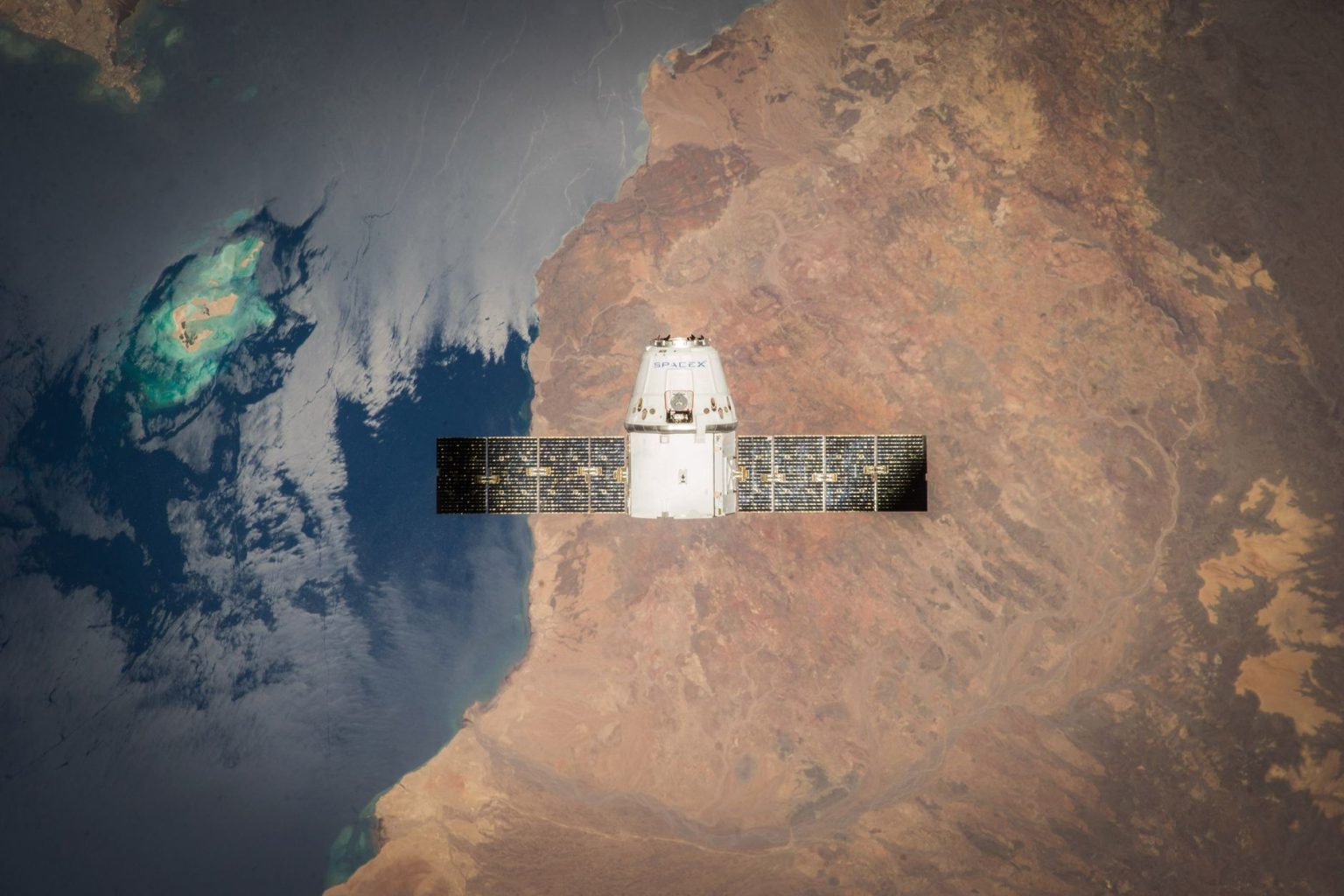 Satélite em órbita sobre a Terra, com o oceano visível ao fundo